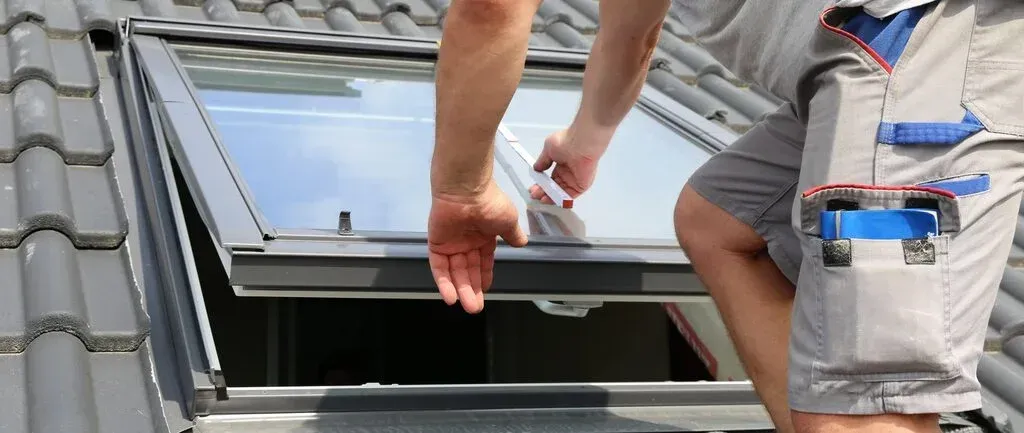 Person installing a skylight on a roof Person installing a skylight on a roof
