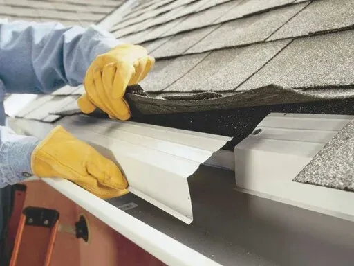 Person installing roofing material on a house Person installing roofing material on a house