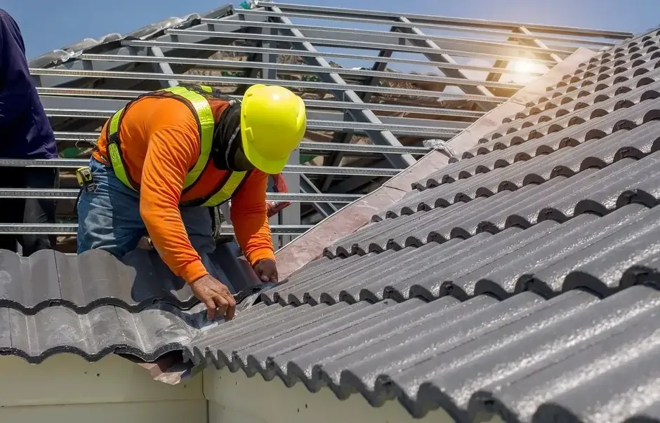 construction worker installs corrugated roofing on a sunny day construction worker installs corrugated roofing on a sunny day