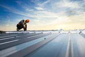 A construction worker inspects a metal roof