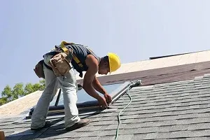 A roofer on a sloped roof